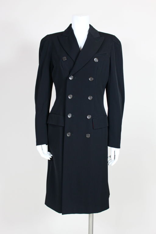 Jean Paul Gaultier black wool twill equestrian style double breasted coat has lightly padded shoulders, shaped sleeves, and illusion flap pockets. Fitted through the waist and flares in the back. Fully lined in printed silk.<br />
<br