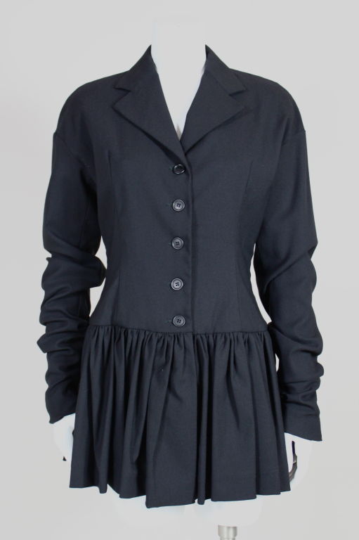 Dolce & Gabbana black wool blend single-breasted jacket with ruffled peplum has extra long sleeves which are worn scrunched and fastened with three buttons at wrist hem. Shoulders are dropped and slightly rounded. Comes with matching long-sleeved