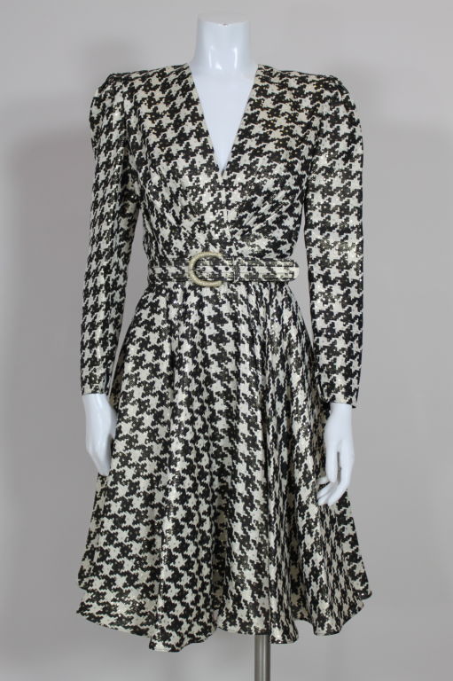 Swingy printed silk lamé brocade dress from Carolina Herrera has a graphic houndstooth pattern shot with metallic gold lamé polka dots. V-neck bodice is pleated from the waist, skirt is cut on the bias. Shoulders are padded. Comes with matching