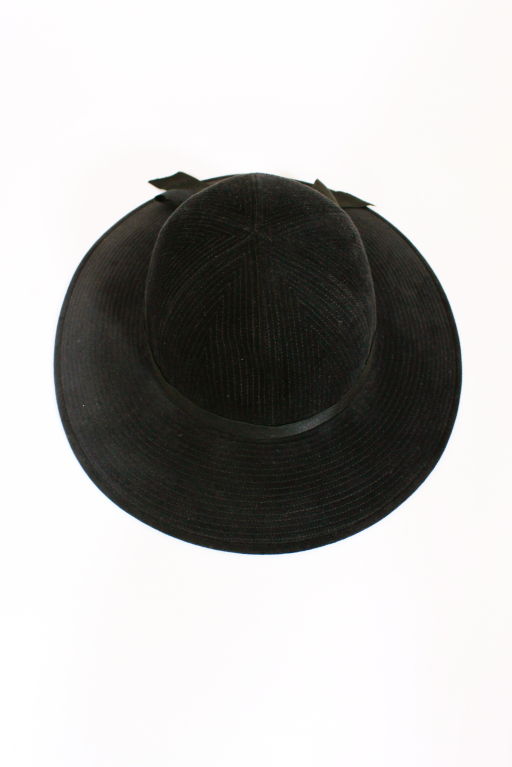 Black fur felt brimmed hat from Chanel has allover decorative topstitching and is trimmed in a black satin ribbon bow. The stitching is designed to resemble corduroy.<br />
<br />
Measurements-<br />
Circumference: 20.5