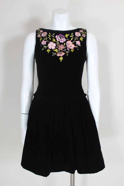 Unlabelled haute couture Christian Lacroix sleeveless black velvet cocktail dress features a decadently embellished neckline with pink satin appliquéd flowers trimmed in lilac, violet and green silk embroidery accented with crystal glass