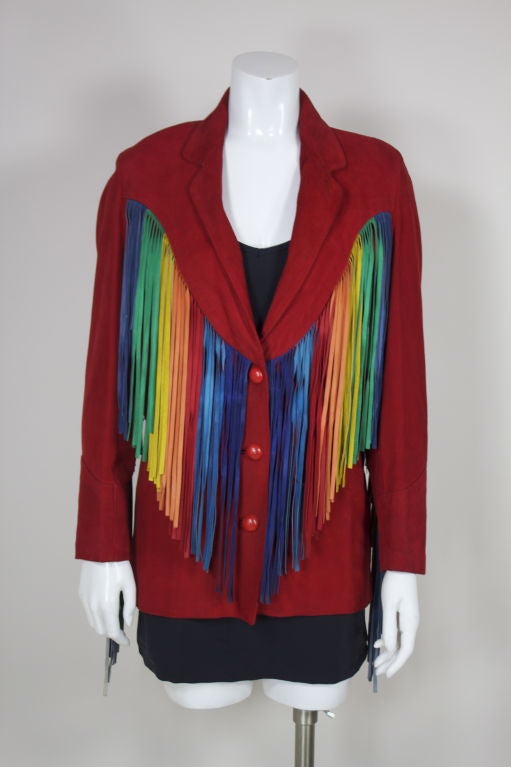 1980's brilliant red suede Western-inspired jacket from Beverly Feldman is trimmed in multi-colored suede fringe along yokes and sleeves. Single-breasted jacket features two front patch pockets and oversized woven red leather buttons. Decorative