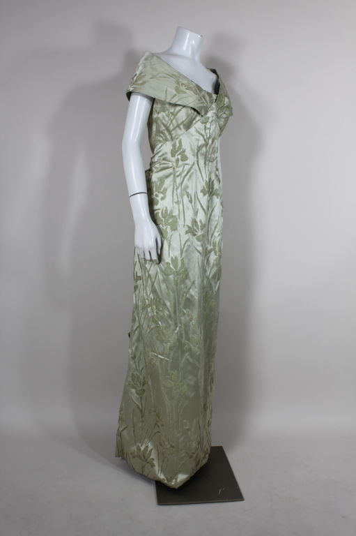 Elegant soft pistachio green silk gown from Elizabeth Arden features an art nouveau-inspired iris shaved velvet motif. Strapless gown has off the shoulder attached wrap panel. Skirt is pleated into a modified bustle and is accented with bows. Fully