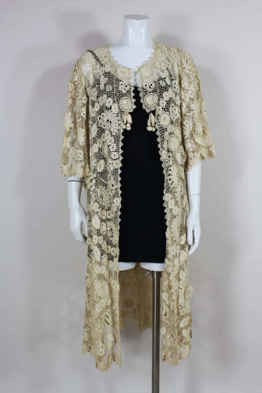 Edwardian handmade Irish crochet lace jacket features dimensional floral appliques, scalloped hem and decorative crochet tassels at front neck. Color is a slight ecru.<br />
<br />
Measurements-<br />
Bust: up to 40”<br />
Waist: 40”<br />
Hip: