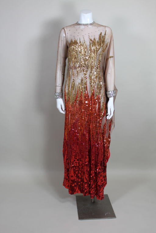 A phenomenal, one of a kind performance outfit designed by Nolan Miller for R&B super-star Gladys Knight, this asymmetrical caftan is embroidered with iridescent sequins in an ombre flame pattern.  Sequins of varying sizes are sewn onto a sheer nude
