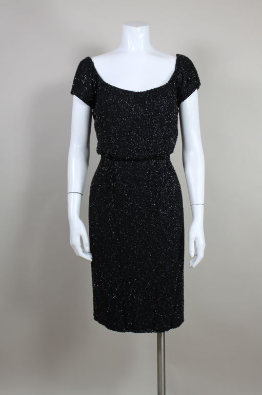 Lovely 1950’s Ceil Chapman party dress shimmers with glass jet beads that are vermicelli embroidered on a crepe ground. Classic 1950’s silhouette is emphasized with elegant cap sleeves, scoop neck, slight blouson bodice and slim fitting skirt. Fully