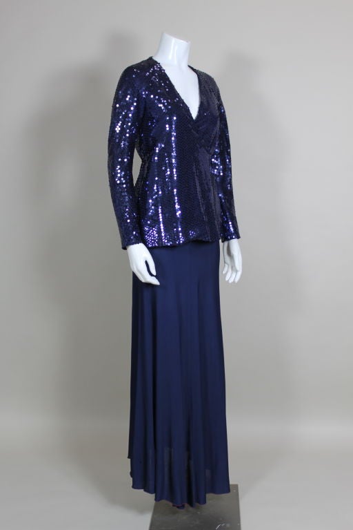 Fabulous two piece ensemble from American designer, Stephen Burrows features a high-waisted slinky maxi skirt in midnight blue jersey and a sequined wrap jacket with raglan sleeves. Skirt is edged in Burrow's signature zig zag stitching in
