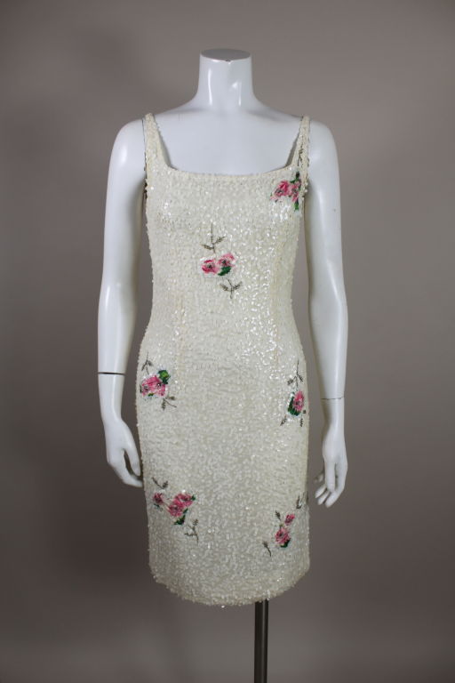 Ultra-modern 1960s sleeveless cocktail dress in delicate sequins and floral appliquéd inserts.  White sequins on silk chiffon are embroidered all over in a dense vermicelli pattern.  The dress has a scoop front and back neckline.  Sexy and sweet. 