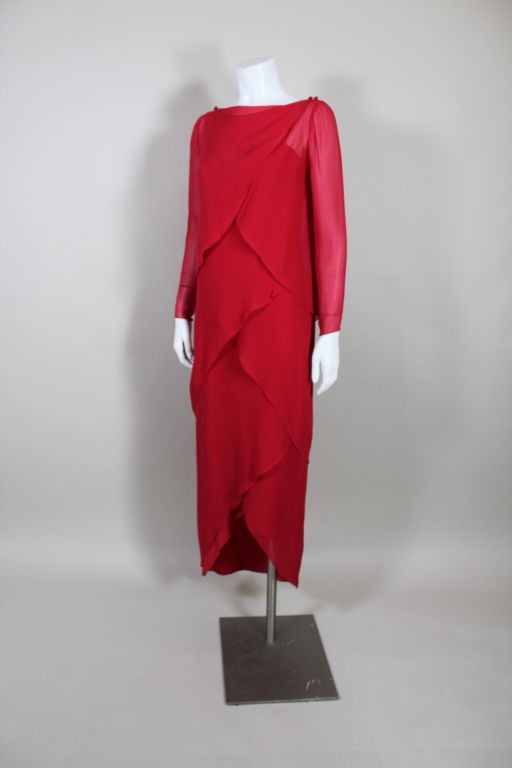 Fabulous lipstick red silk gown from Bill Blass is made from layers of overlapping chiffon in a tiered petal silhouette. Comes with a matching long sleeved capelet that wraps and fastens at the shoulders with self covered buttons. <br />
<br