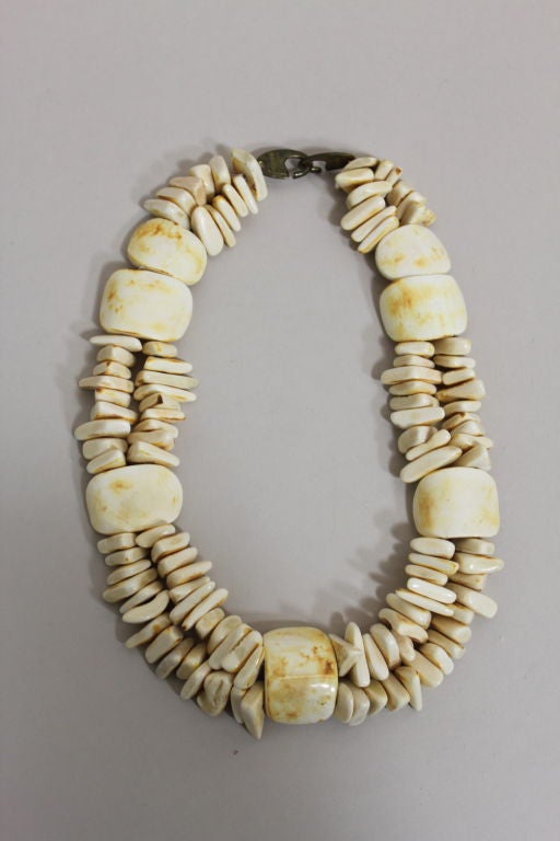 Gorgeous polished horn jewelry set from iconic designer Monies is made from irregularly shaped beads and oversize curved center pieces. Ivory colored beads show natural striations beautifully. Double strand necklace fastens with oversize metal hook