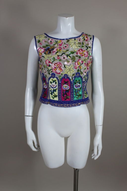 Absolutely gorgeous, embellished sleeveless shell from Valentino is entirely hand embroidered with silk threads, micro sequins, crystals and glass beads. Vivid floral motifs are embroidered onto multi-colored satin panels that are framed by beaded