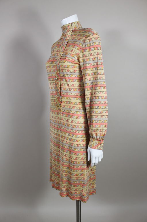 Gorgeous printed silk jersey dress from Pucci has a geometric pattern in alternating bands of solid colors and color-blocked waves in desert sunset shades. Sleeves blouson subtly over fitted cuffs. High collar snaps closed. Off-set illusion placket
