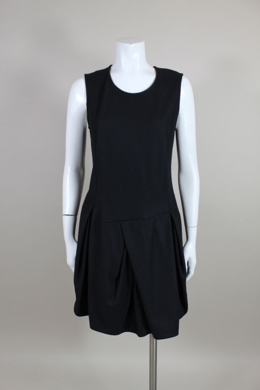 Comme des Garçons wool dress has a 60's inspired drop waist silhouette. Skirt is manipulated into asymmetrical pleats for volume. Zip back. Meant to be loose and somewhat oversized.<br />
<br />
Measurements-<br />
<br />
Bust: 36”<br />
Waist:
