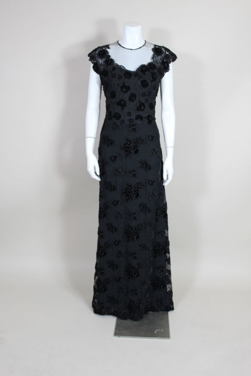 Dark and dramatic guipere lace gown from Ungaro couture is covered in dimensional appliquéd velveteen flowers. Silk net neckline is trimmed in jet beads. Gown fastens down the back with small domed buttons. Fully lined. <br />
<br