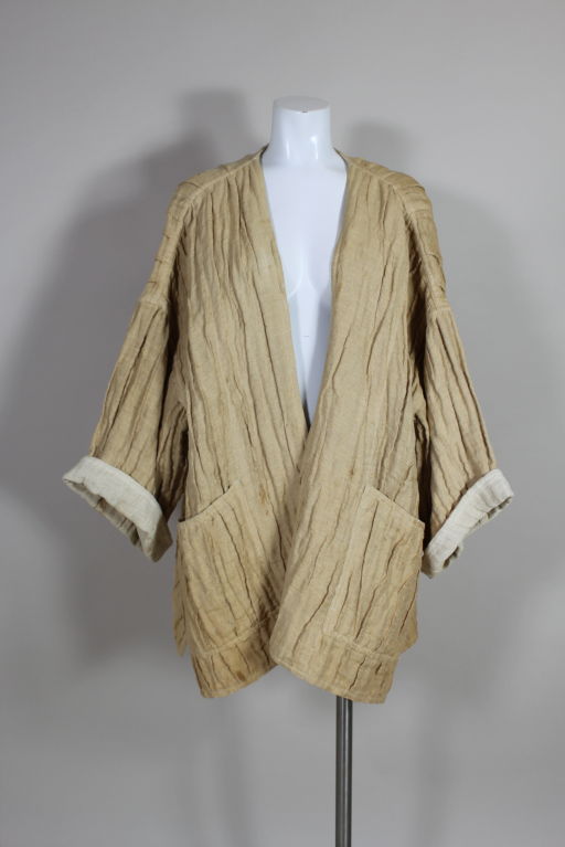 This amazing creation from Issey Miyake puts a new spin on his iconic pleating techniques. Oversized coat is done in a tea-dyed utilitarian-chic burlap with dropped shoulder, cuffed kimono sleeves. <br />
<br />
Measurements-<br />
<br />
Bust: