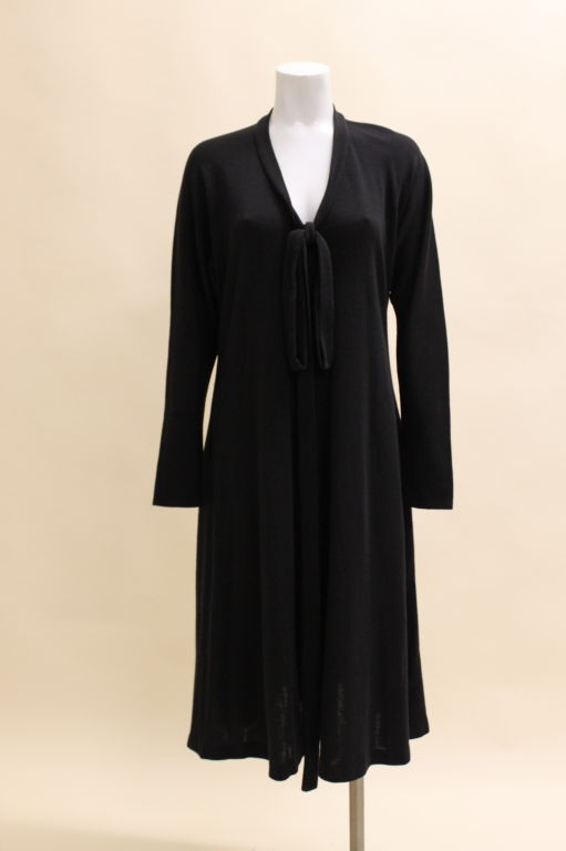 Perfect for fall, this swingy Halston dress is done in a lightweight wool jersey in a trapeze silhouette. V-neck dress has a sash-tie collar.<br />
<br />
Measurements-<br />
<br />
Bust: 42