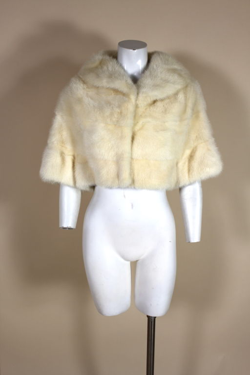 Fantastic mid century ivory mink bolero is the perfect cover-up for brisk autumn evenings. Short sleeves give the impression of a capelet. Fastens in the front with thread wrapped hook and eye fasteners and is fully lined in satin.<br />
<br