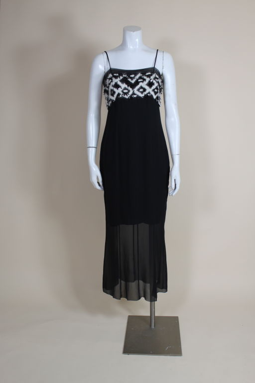 Fantastically chic party dress from Chanel is done in the house's iconic black and white palette. A cashmere-yarn embroidered bodice is embellished with jet beads and black celluloid strips on a chiffon ground. Dress is lined with a short black