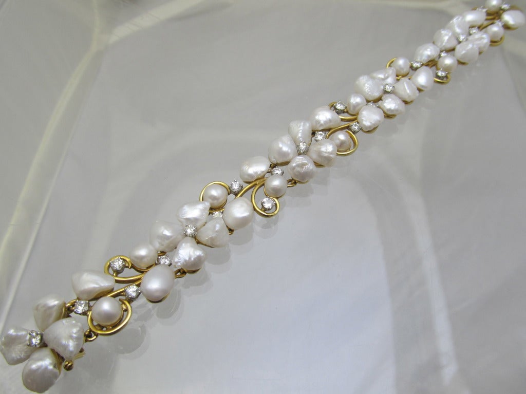 Ruser!  This beautiful platinum & yellow gold  flower on a wine motif bracelet  has 40 fresh water pearl buds & flower petals 
 25 brilliant diamond water drops on the vine.
Diamond estimated weight is 2cts
Signed 
