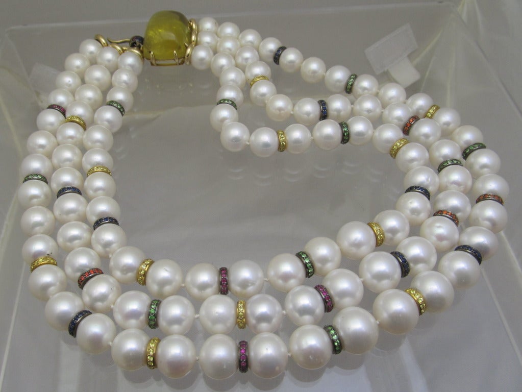 Michele Della Valle cultured pearl & colored stone necklace.

The triple-strand necklace composed of 103 cultured pearls measuring approximately 13.3 to 11.3 mm,
The clasp set with a cabochon citrine weighing app. 68.75 carats,
 The clasp and