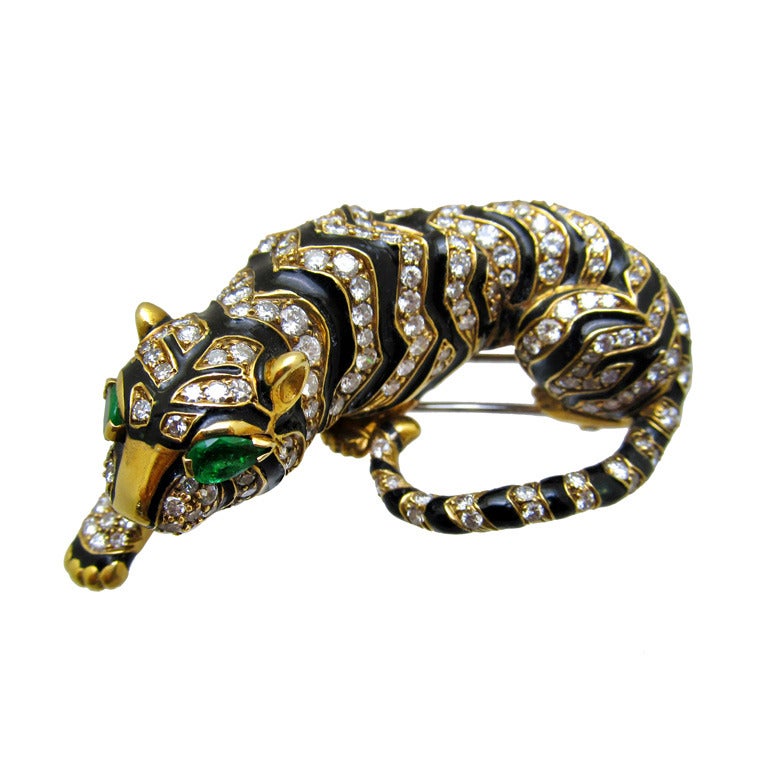 Designed as a crouching tiger with black enamel and round brilliant-cut diamonds and pear-shaped emerald eyes.
 Signature design by David Webb.
 The  estimated weight of diamonds is 9cts 
 2 emerald eyes are .0.35cts
 18kt yellow gold, signed
