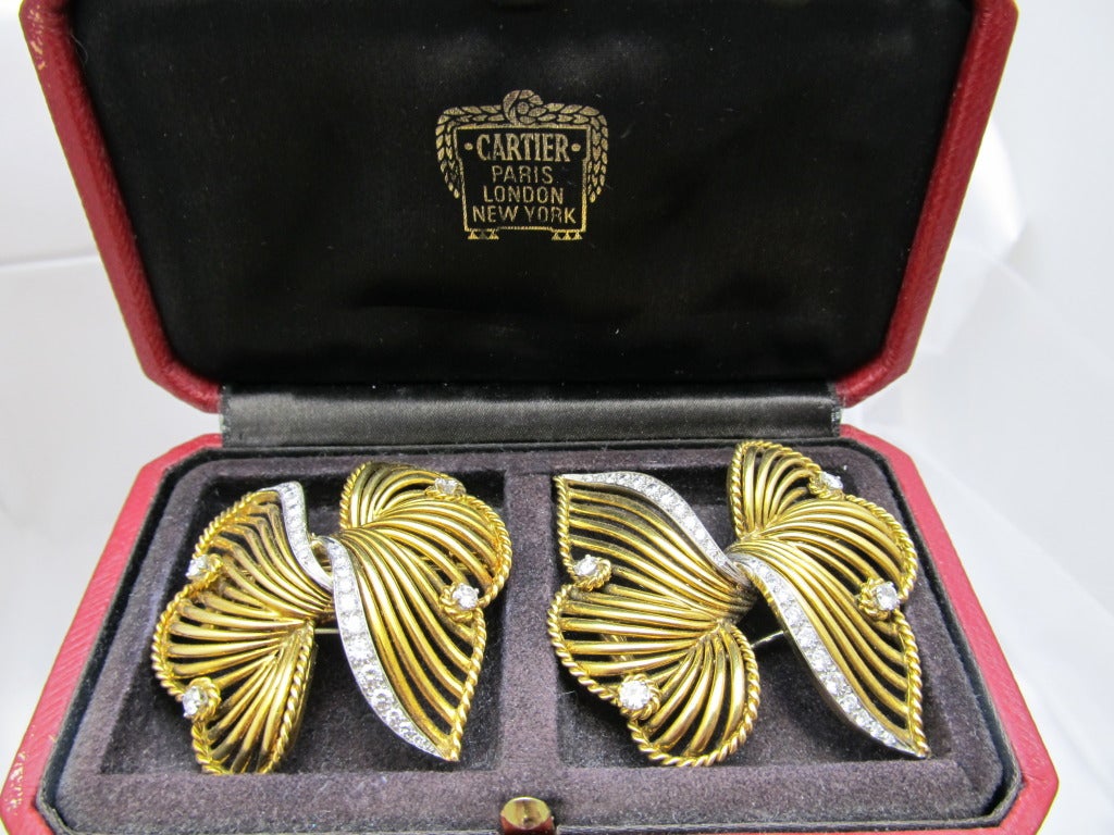 Exquisite Cartier double brooch.
18k gold bow tie look brooches,bordered with rope design &   diamonds encrusted in platinum .
Signed: Cartier 
Serial # 1482
In Cartier box