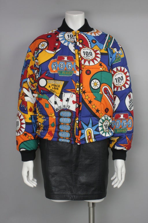 Multicolored polyester puffer coat with pinball print allover. Bomber style with rib knit cuffs and collar.