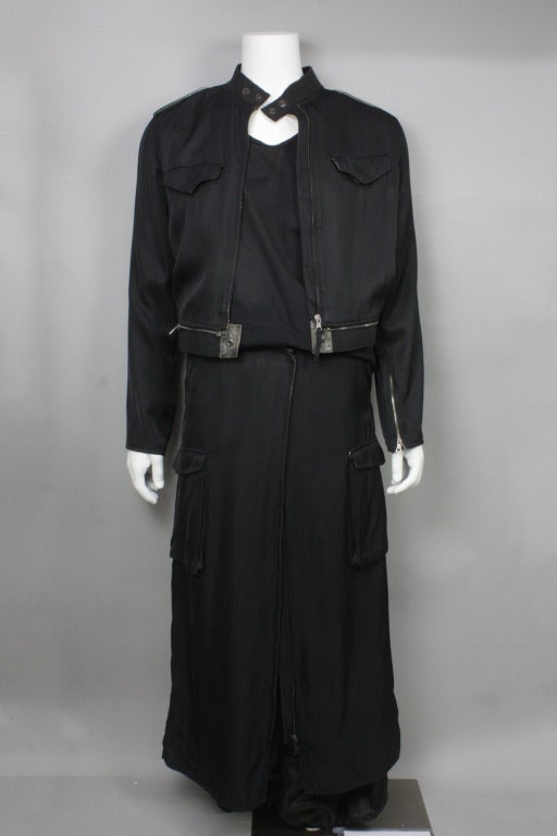 Acetate trench with a configuration of zippers that converts the piece into a bomber jacket and skirt.