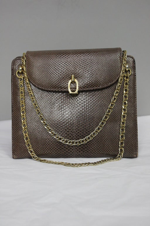 Originally $495!
Brown lizard skin handbag with double chain handles. Two main compartments and three inner pockets, one with zipper. 6.5