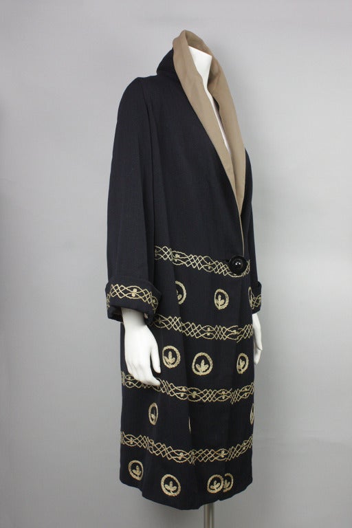 Wool coat with shawl collar and single large button at waist. Hand embroidered.