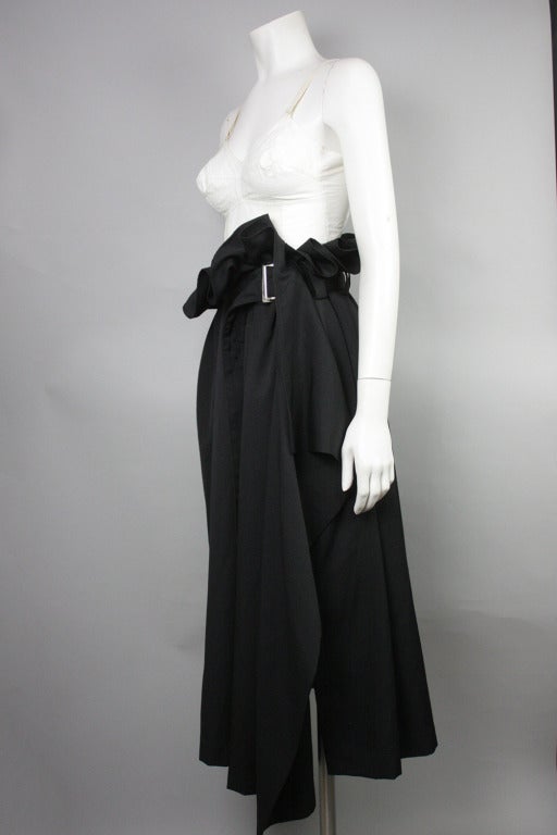 Black wool paper bag waist skirt with asymmetrical hem. Coordinating belt with silver buckle. One pocket at right side. 

Yohji size 2, please see last image for measurements.