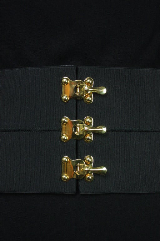 Statement making black elastic belt with three gold-tone clasps from Prada. Circa 2000s.  

4.63