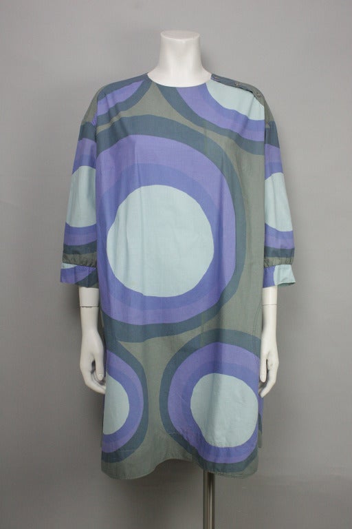 Finnish company Marimekko made its mark in the '60s with bright colors and striking prints like that of this dress. Cotton circle print dress with slit pockets at the hip. Three buttons on the left shoulder. Optional fabric belt.