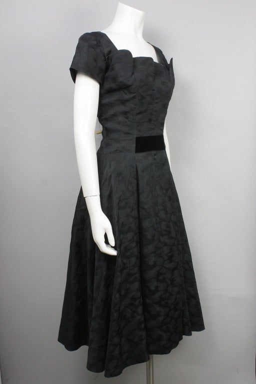 Gorgeous black silk dress by Hattie Carnegie. Velvet accents and subtle marbled effect to the fabric. Inner lining with boning. Lining and shell close at back with their own zippers. Shown with crinoline, not included.