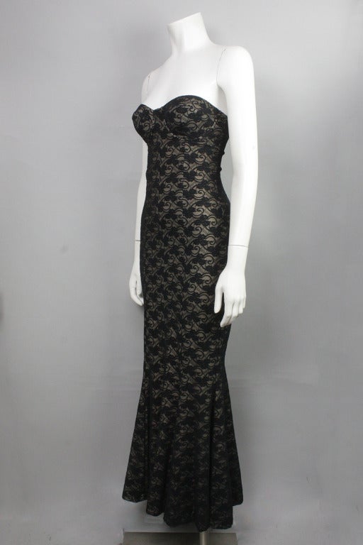 Sleek, strapless stretch dress with beige lining and black lace overlay. Mermaid shape. Underwire cups. No zippers or clasps. 

Please note that the measurements listed are minimums; this dress allows for a significant amount of stretch.