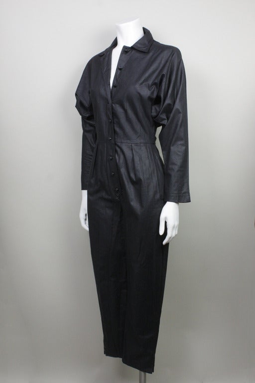 Long sleeve button down jumpsuit with an accented waist. Slit pockets at hips.