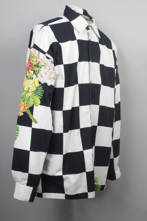 Estampado en damero blanco y negro intercalado con motivos florales. Camisa de algodón para hombre con botones dorados con el logotipo del sol de Versace.