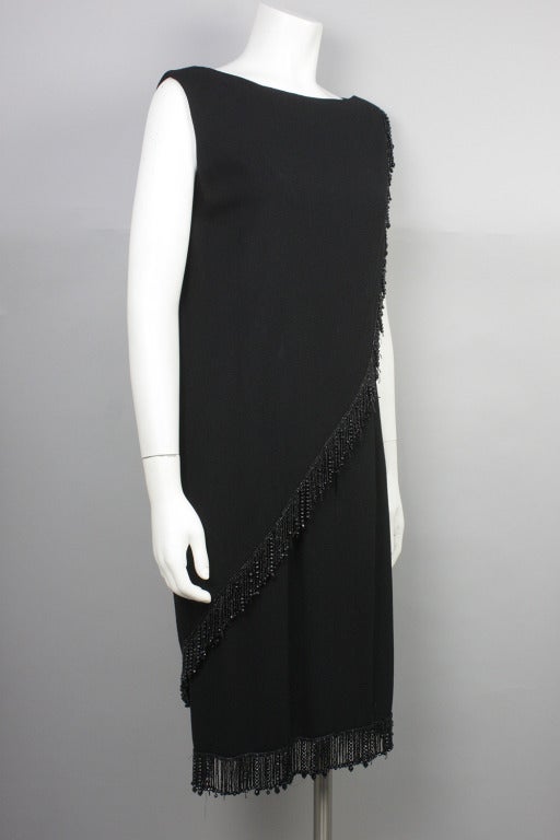 20% OFF! Originally $895

Black sleeveless wool crepe cocktail dress with a cascading wrap top layer and hem with beaded fringe. By designer and costumer Jean Louis, famous for designing Marilyn Monroe's 
