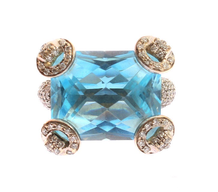 This is a beautiful Gucci 18K White Gold Dinner Ring, with a large checkerboard blue topaz, the corners with pierced pave diamond mounted supports, on a scrolled band with pave diamond mounts, ser. # 3114217B, with a Gucci certificate of