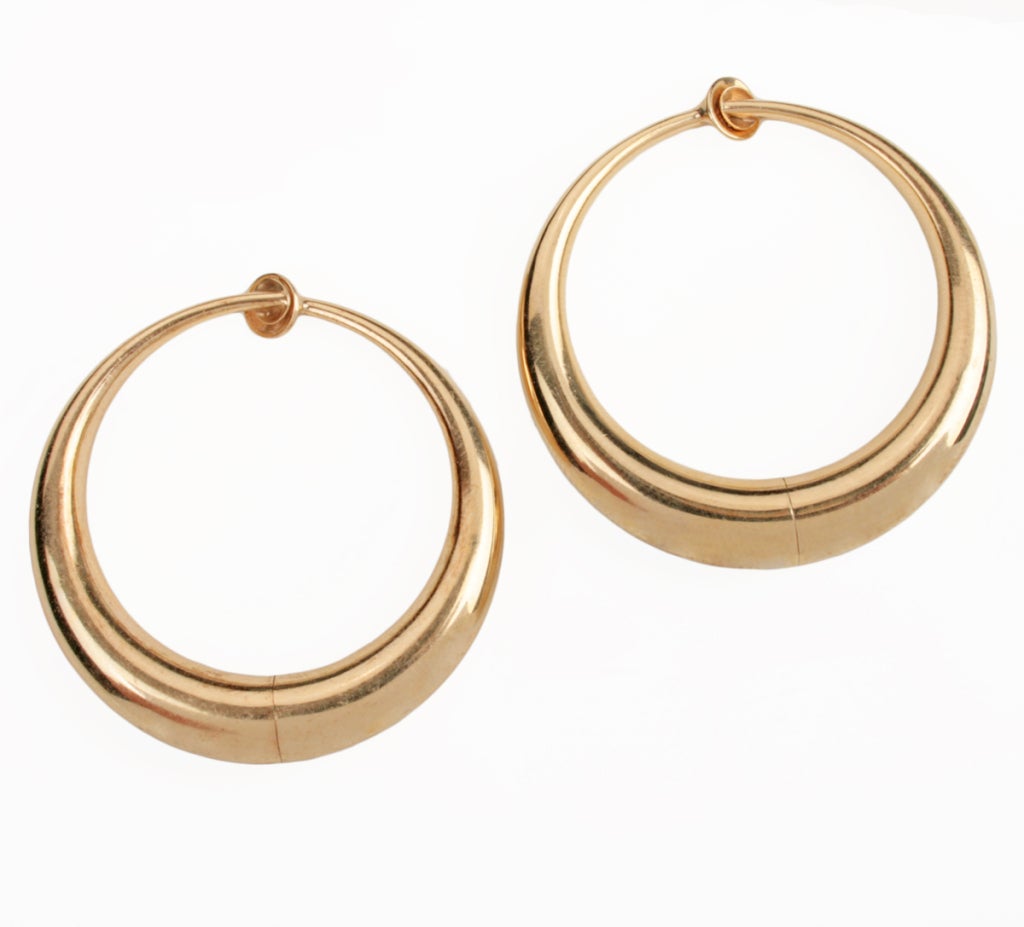 These are great looking  and nicely made gold hoop earrings. A spring loaded twisting connection allows the two halves of the earrings to pivot open and closed. They are marked Pat. 2611251, 14 and a makers mark.