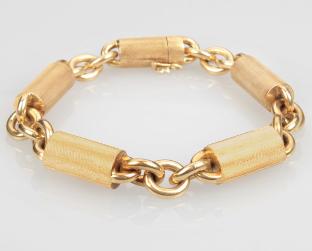 This is a handsome 18 kt gold link bracelet comprised of cylinders of florentined gold. Originally sold at Chicago's CD Peackock, it is also marked Italy with a coat of arms, K18 and SVR.