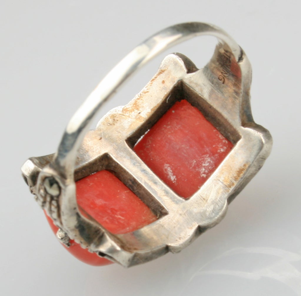 An Art Deco period ring made with sterling silver, coral and marcasite. Shown with two other art deco period rings by Theodore Fahrner.