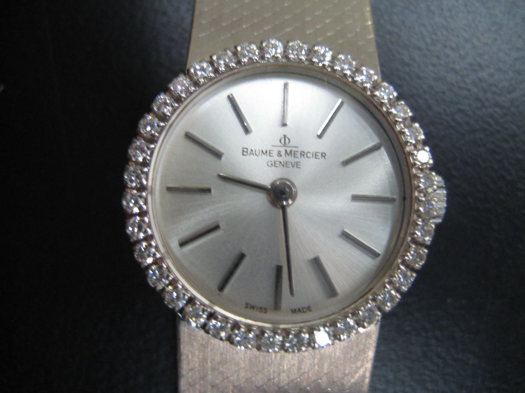A gorgeous 1960s Baume & Mercier 18K white gold ladies watch with diamonds surrounding the face.  Serial number etched on back.