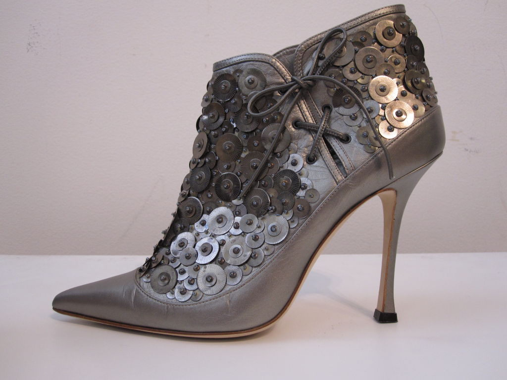 Manolo Blahnik Gunmetal metallic leather bootie in gunmetal with metal disc embellishment and side lacing.  Size 41. Barely worn.
