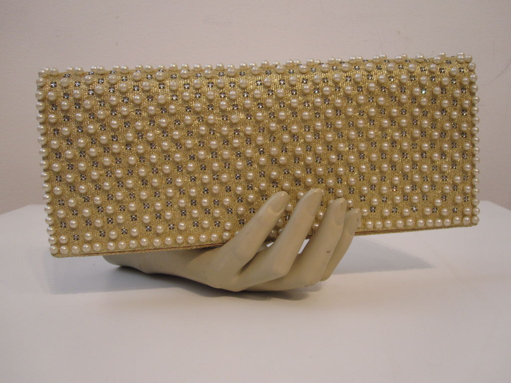 Nettie Rosenstein 60s evening envelope clutch in gold lamé fabric covered in pearls studs and rhinestones. Gold satin lining with elasticized pocket.<br />
<br />
Measures 10.25
