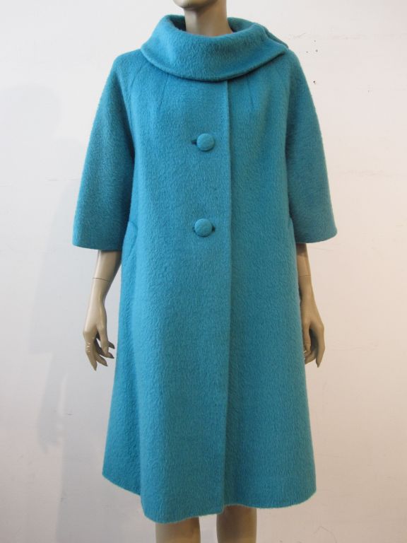 A wonderful 60s Lilli Ann wool coat made is gorgeous aqua color French-made wool and mohair fabric with trapeze shape, 3/4 sleeves and side closure collar.  Lined in rayon satin. Approx. size 6.