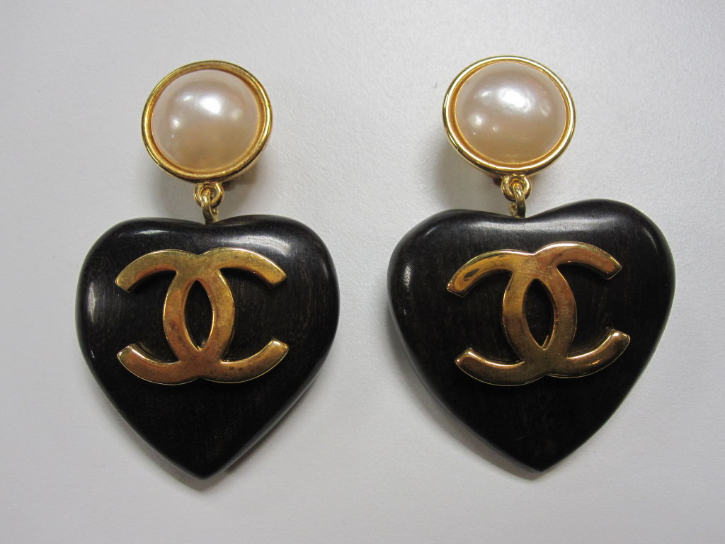 Chanel clip-on earrings with faux pearls and heart drop made of ebony with a gold-tone metal double C logo.  Measuring 2.75