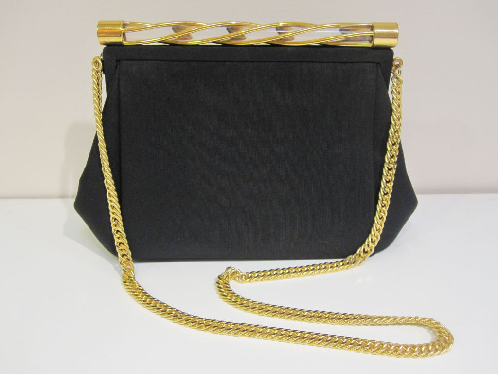 Gorgeous sleek Bienen-Davis 1950s black faille handbag with twisted lucite and gold top detail and chain handle  Black satin interior in very good condition with one small faded spot deep inside.  Zippered pocket. <br />
<br />
Measures 10