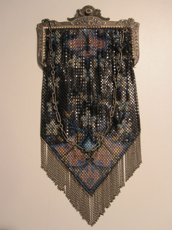 A beautiful French-made enameled Art Deco style metal mesh evening bag with elaborate cast plated metal frame and a beautiful black, blue, gold and rose color scheme.  Chain-link fringe is intact.  Silk lining is shattered but could be replaced. 