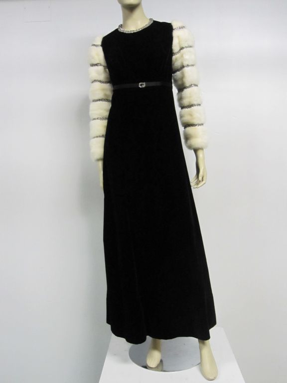 A stunning early 70s Nina Ricci Couture ensemble; gown and matching evening cloak with mink edged hood and satin lining.  Gown is silk velvet with mink sleeves embellished with crystal and lame trim.  Satin belt is embellished with a rock crystal